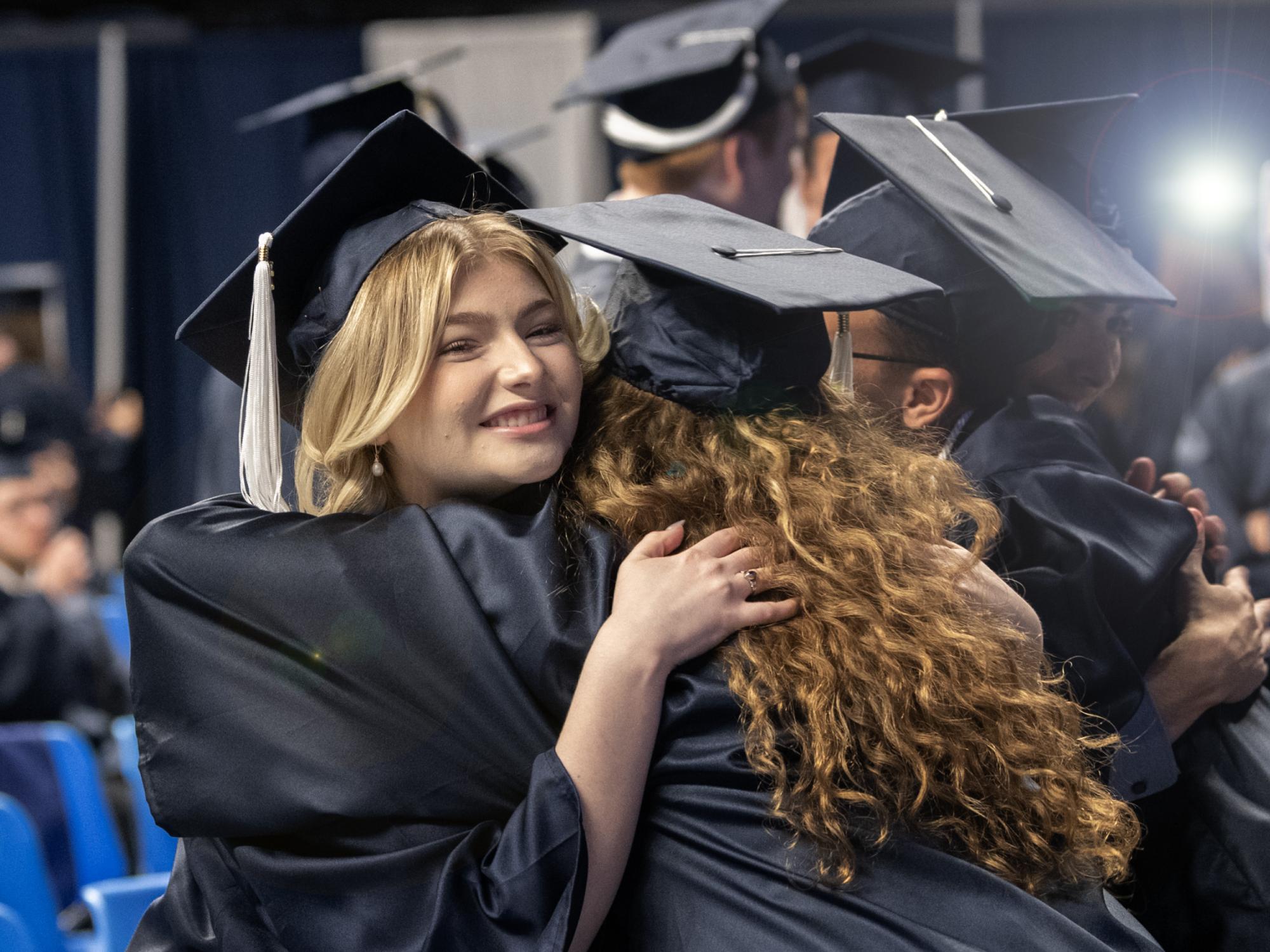 graduates hugging