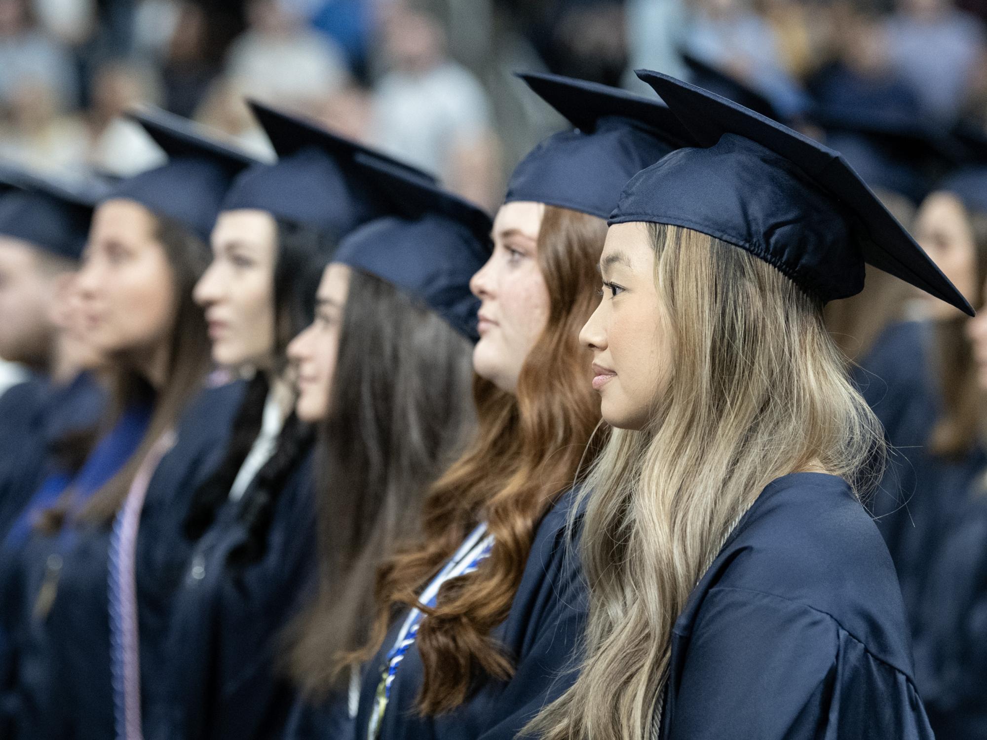 graduates stand during academic procession