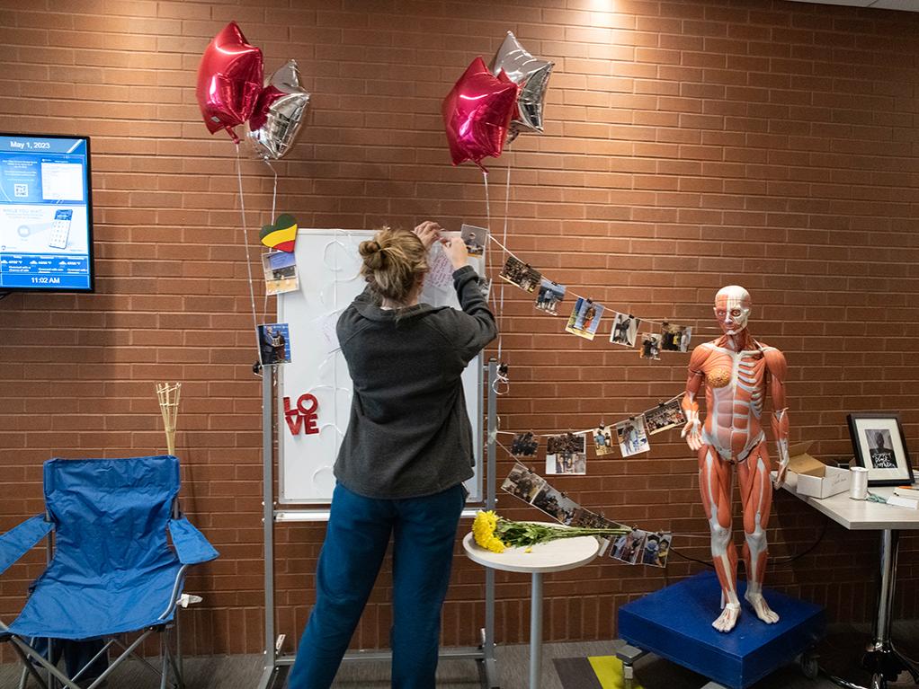 A student contributing words of sympathy and remembrance to an on-campus Carol Evans memorial.