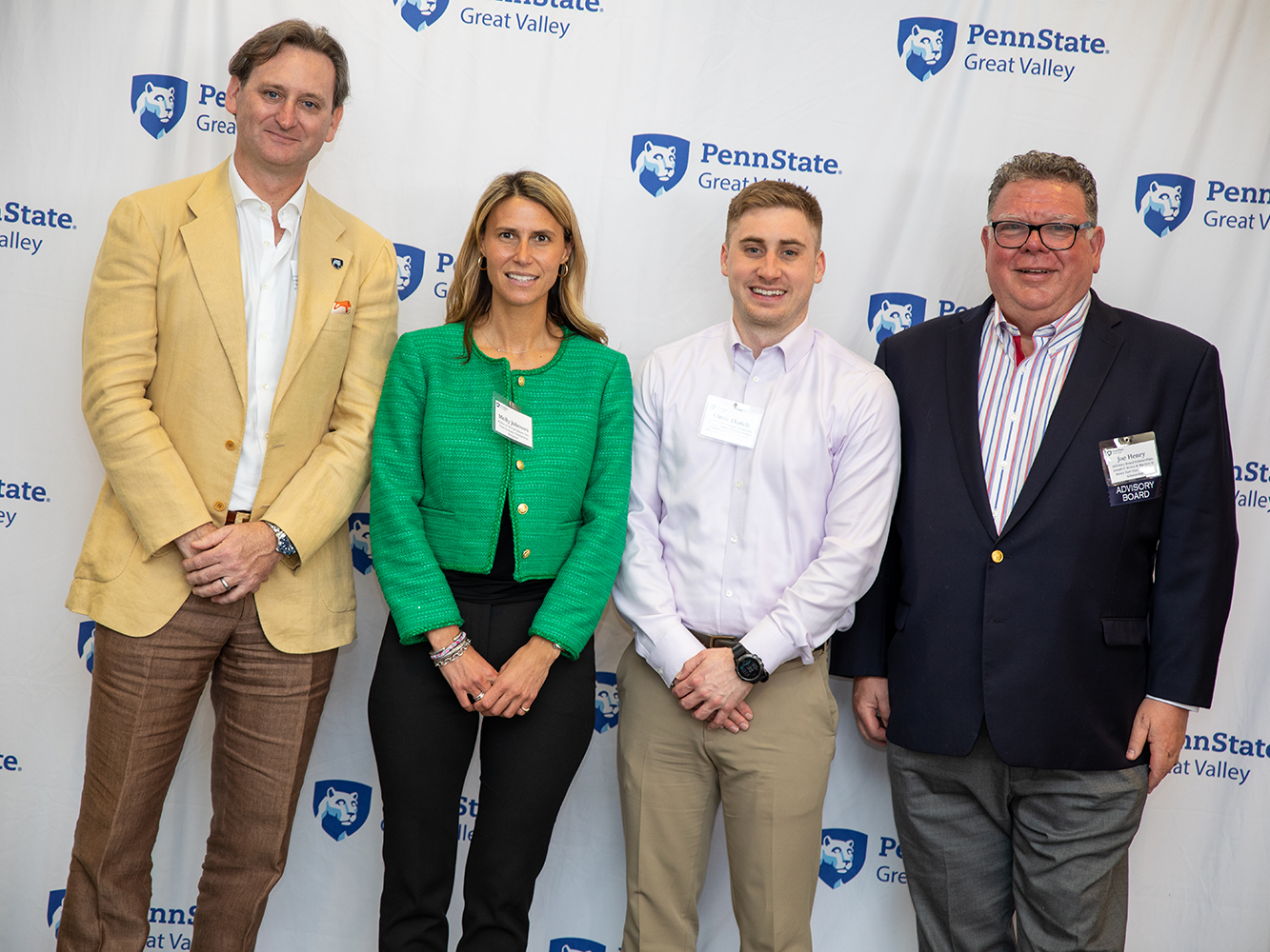 Four people standing in front of a Penn State Great Valley backdrop