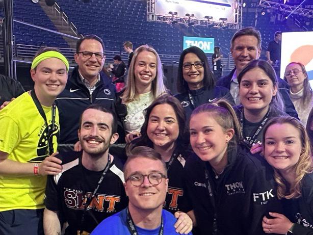 A group of people pose for the camera on the floor of the Bryce Jordan Center during THON 2023.