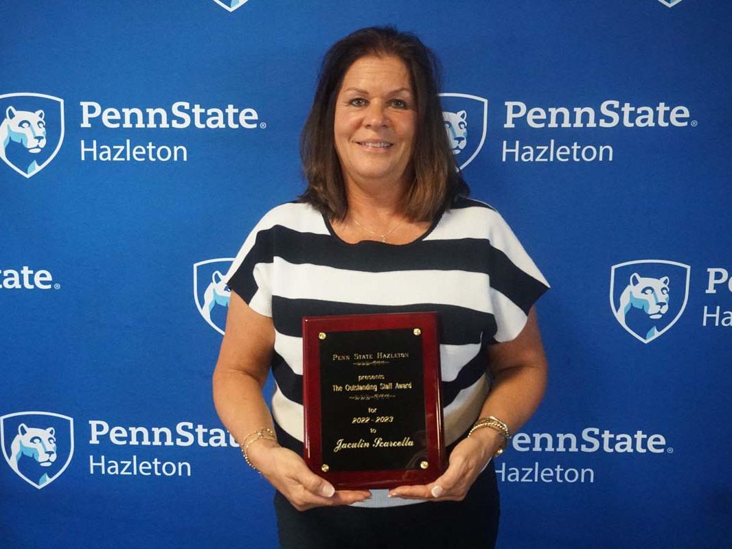 Woman smiling and holding a plaque.