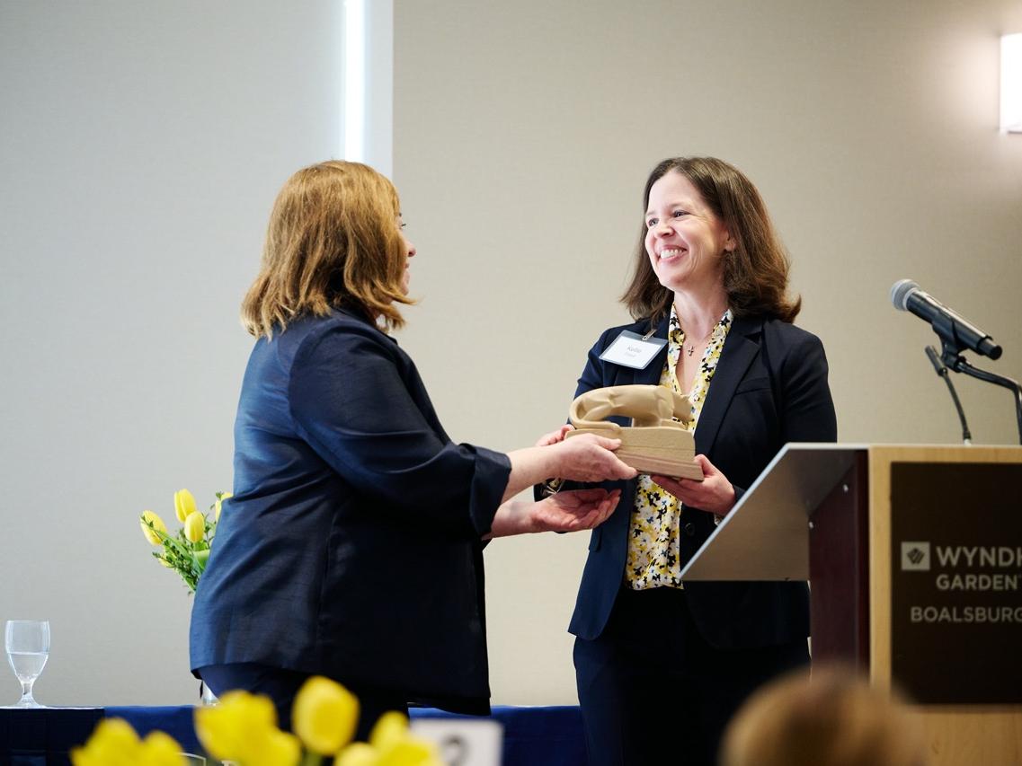 Marie Boltz presents keynote speaker Kellie L. Flood with Penn State Nittany Lion statue. 