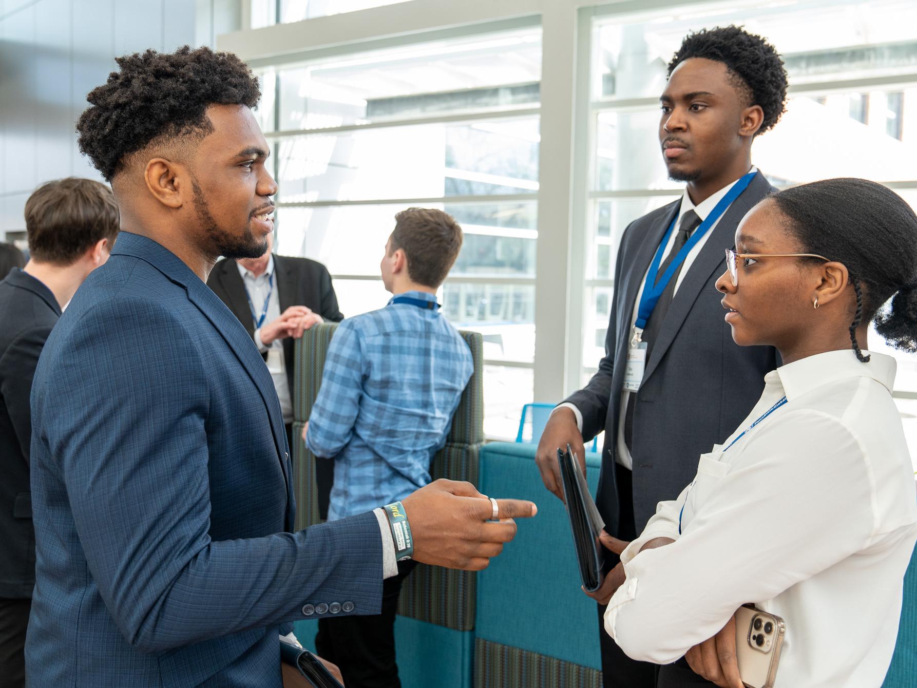 Three people standing in a circle talking