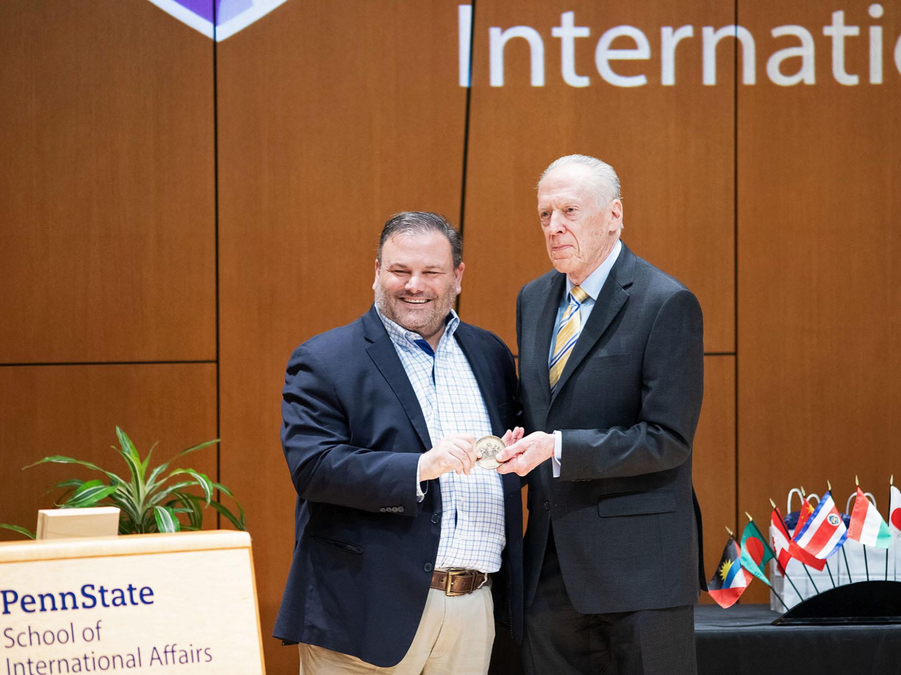 Amb. Dennis Jett (right) accepting his award from Paul Clifford during the ceremony.