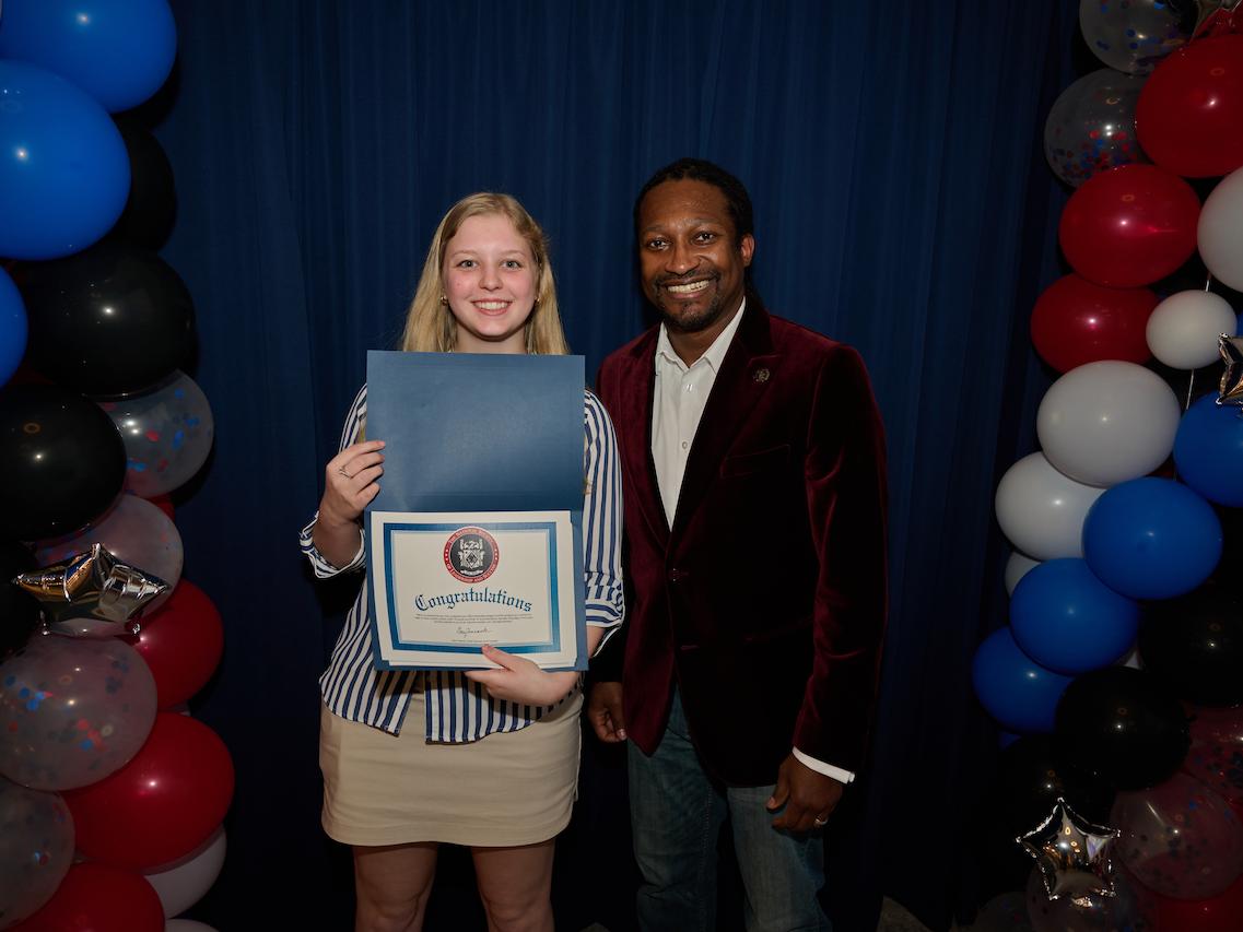woman holding certificate and standing next to man