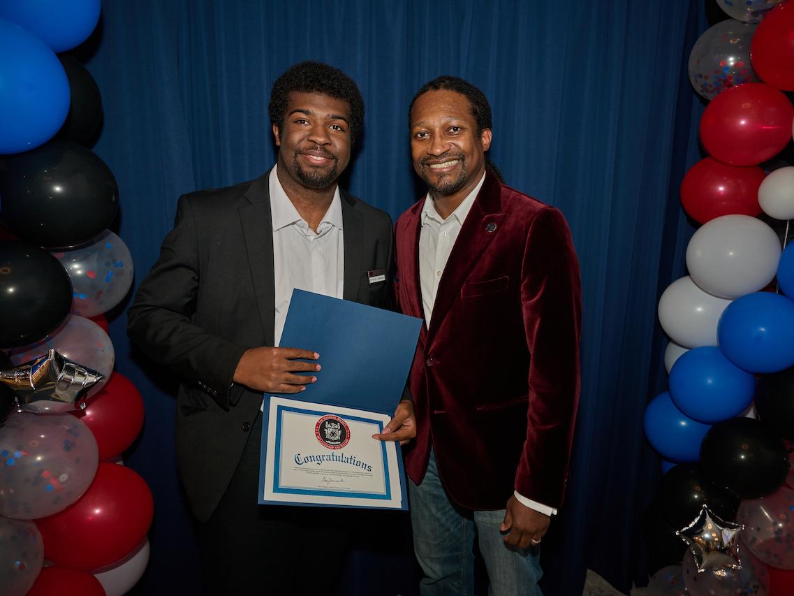 two men standing holding a certificate