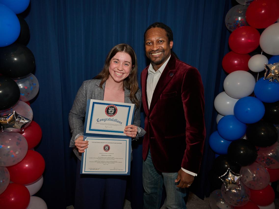 woman holding certificate and standing next to man
