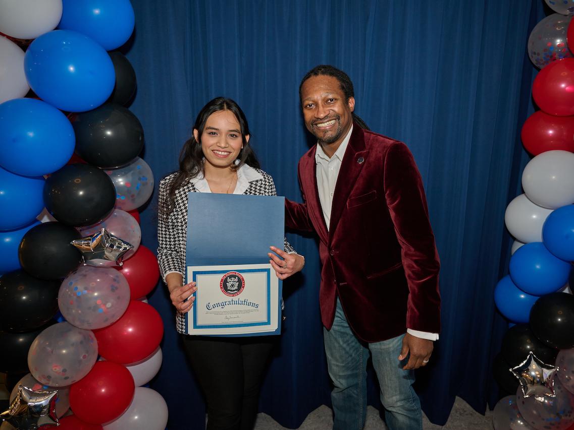 woman holding certificate and standing next to man