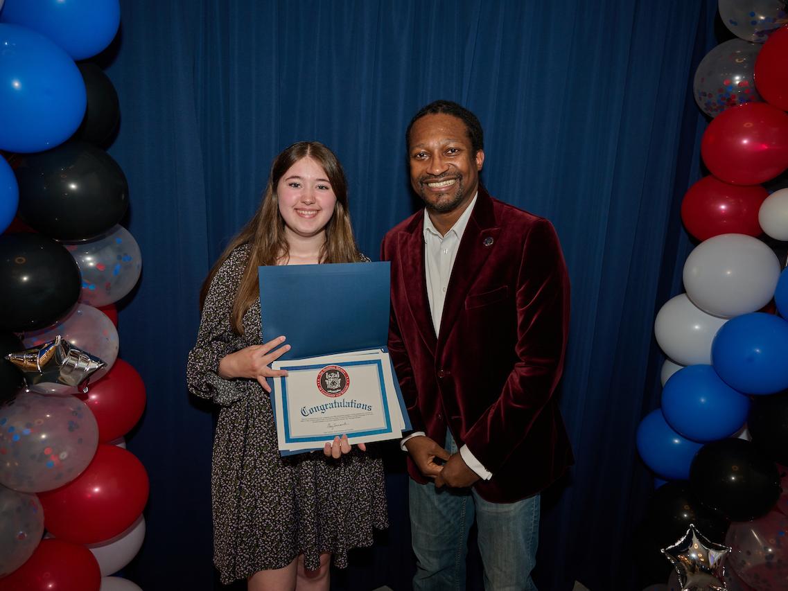 woman holding certificate and standing next to man