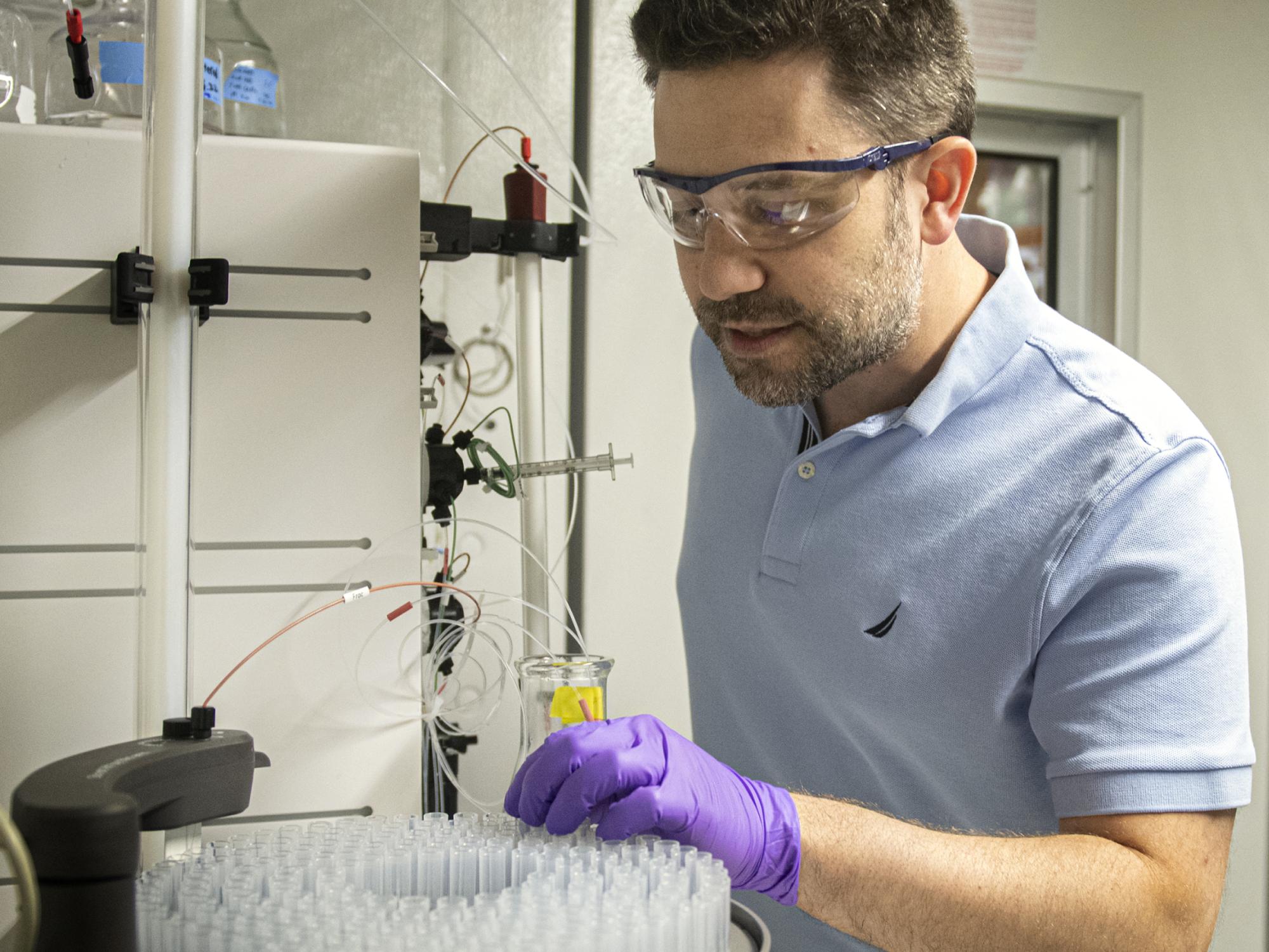 A researcher in the lab wearing gloves and safety glasses