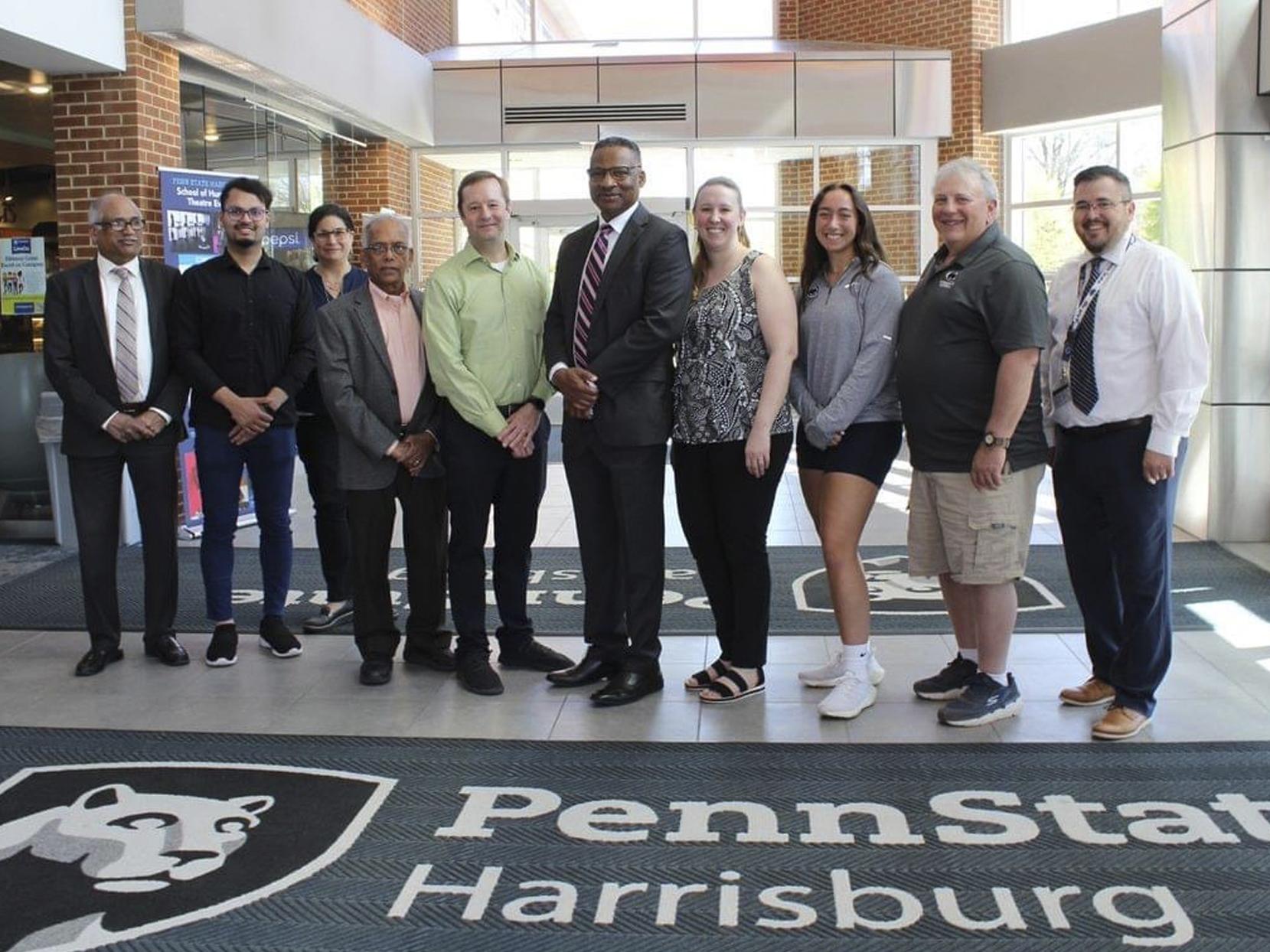 Group photo of ten people standing in the Olmsted Building at Penn State Harrisburg.