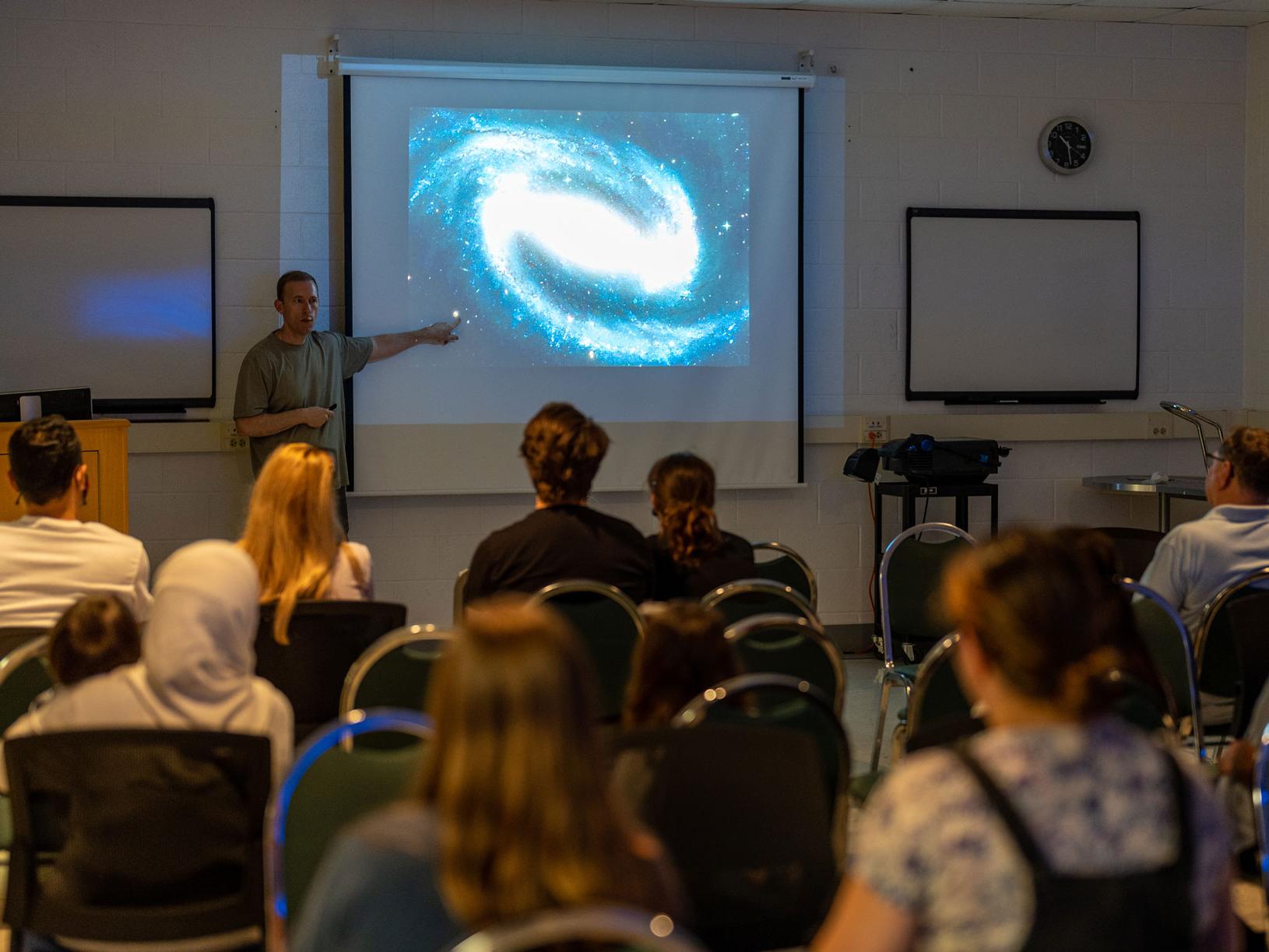 Kevin Luhman points to image of galaxy during presentation