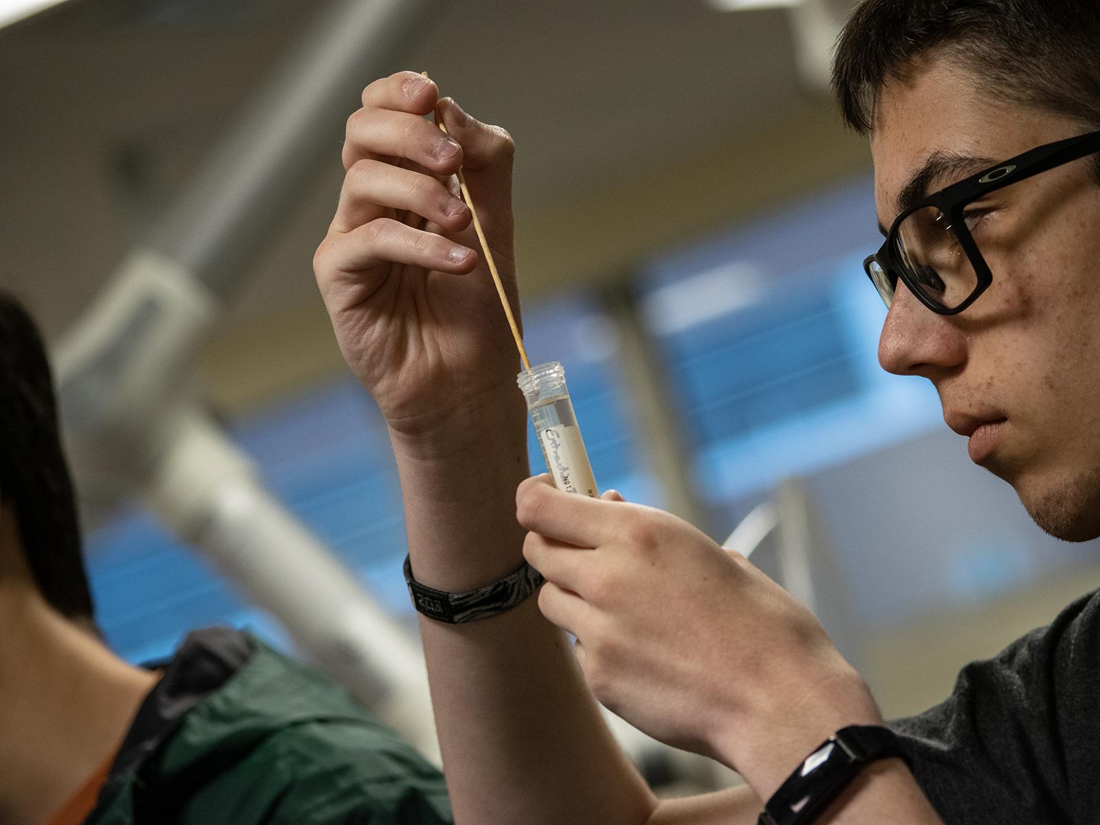A student holds a test tube during a biology workshop