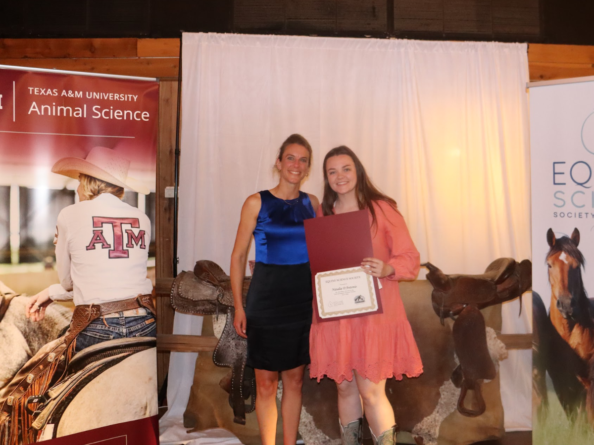 Penn State student poses with her award at the symposium