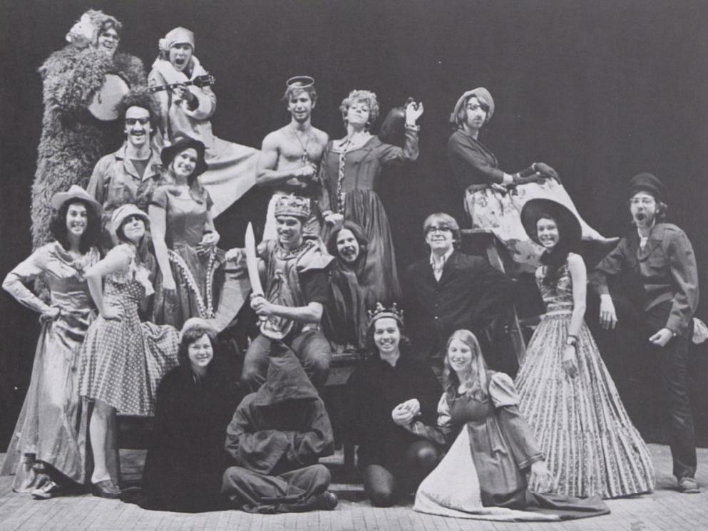 A black and white picture of a group of actors dressed in costume in 1975