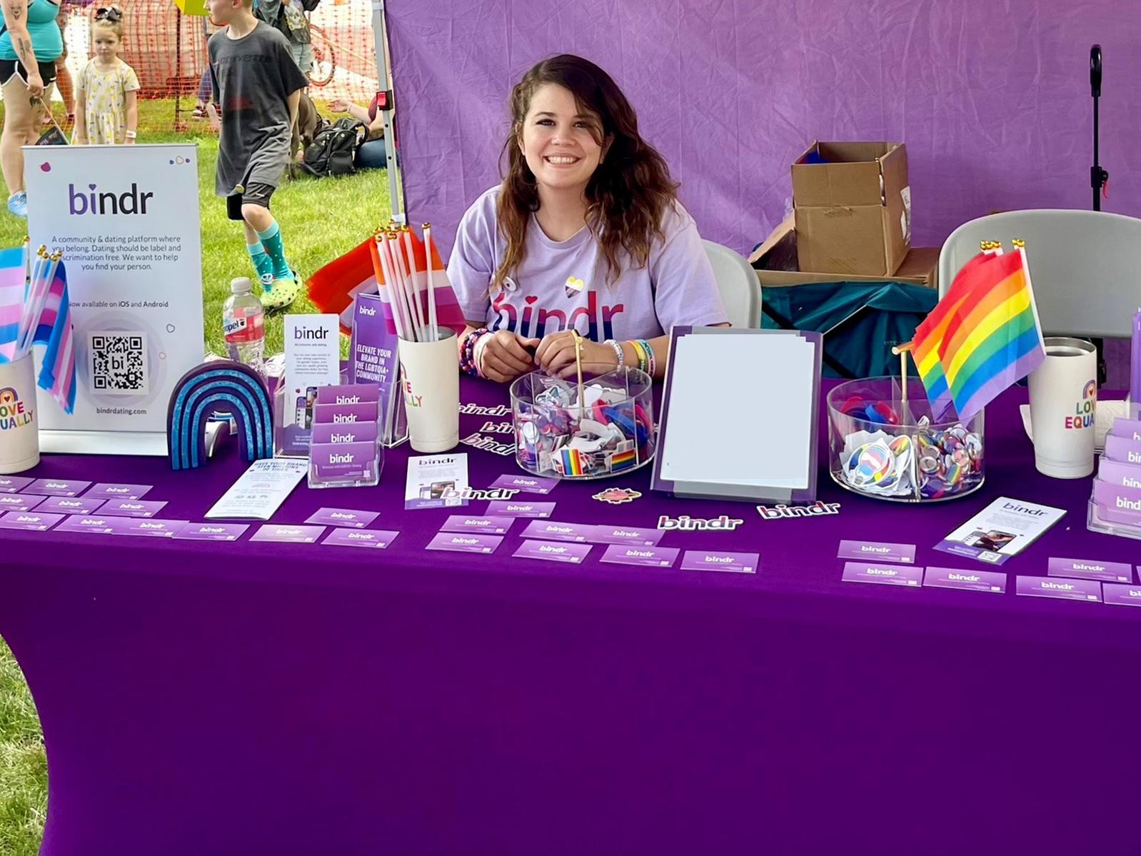 Female with long dark hair displaying items at a vendor table