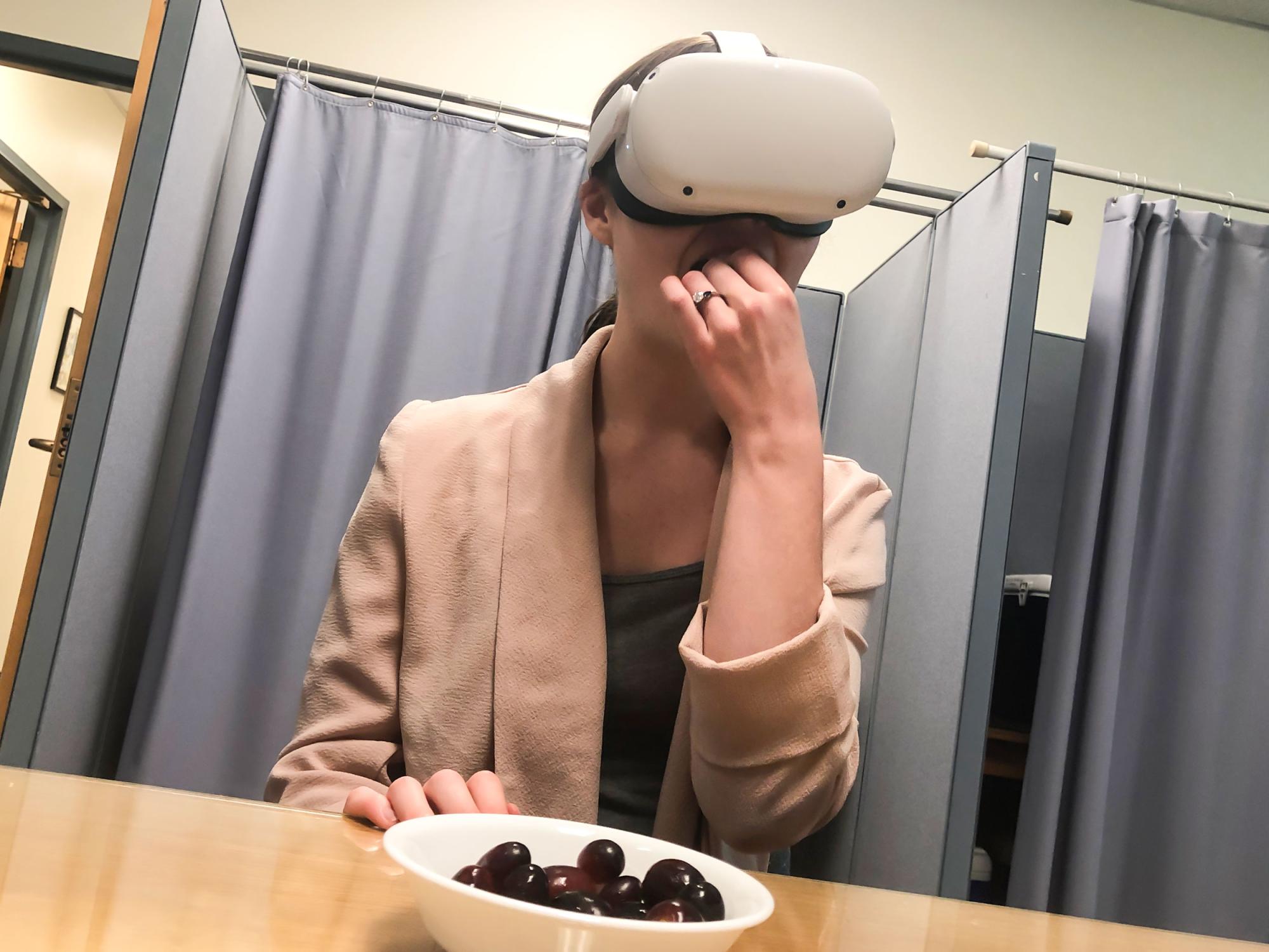woman in virtual reality headset eating grapes
