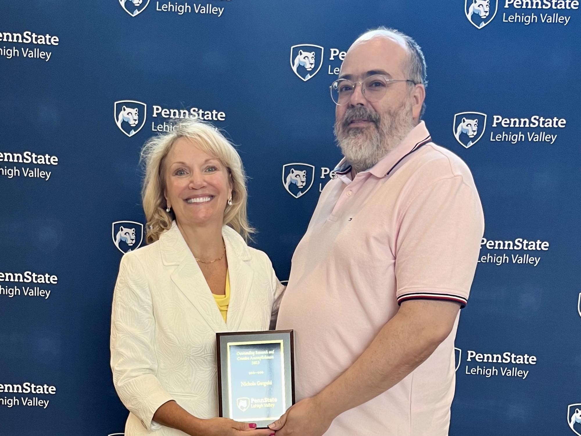 A photo of Dr. Nichola Gutgold receiving the Outstanding Research Award at All Campus Day 2023.