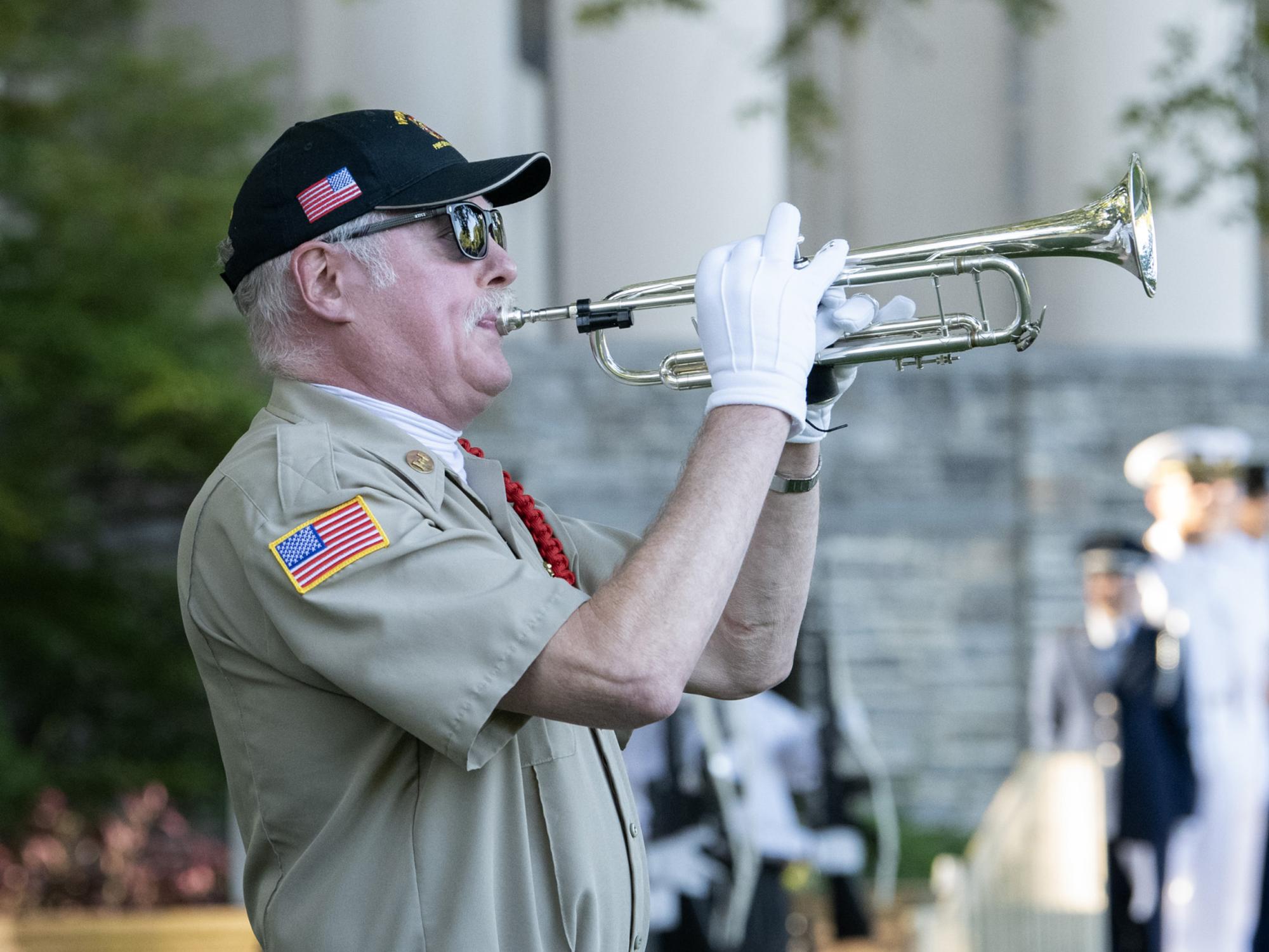 A bugler plays Taps.