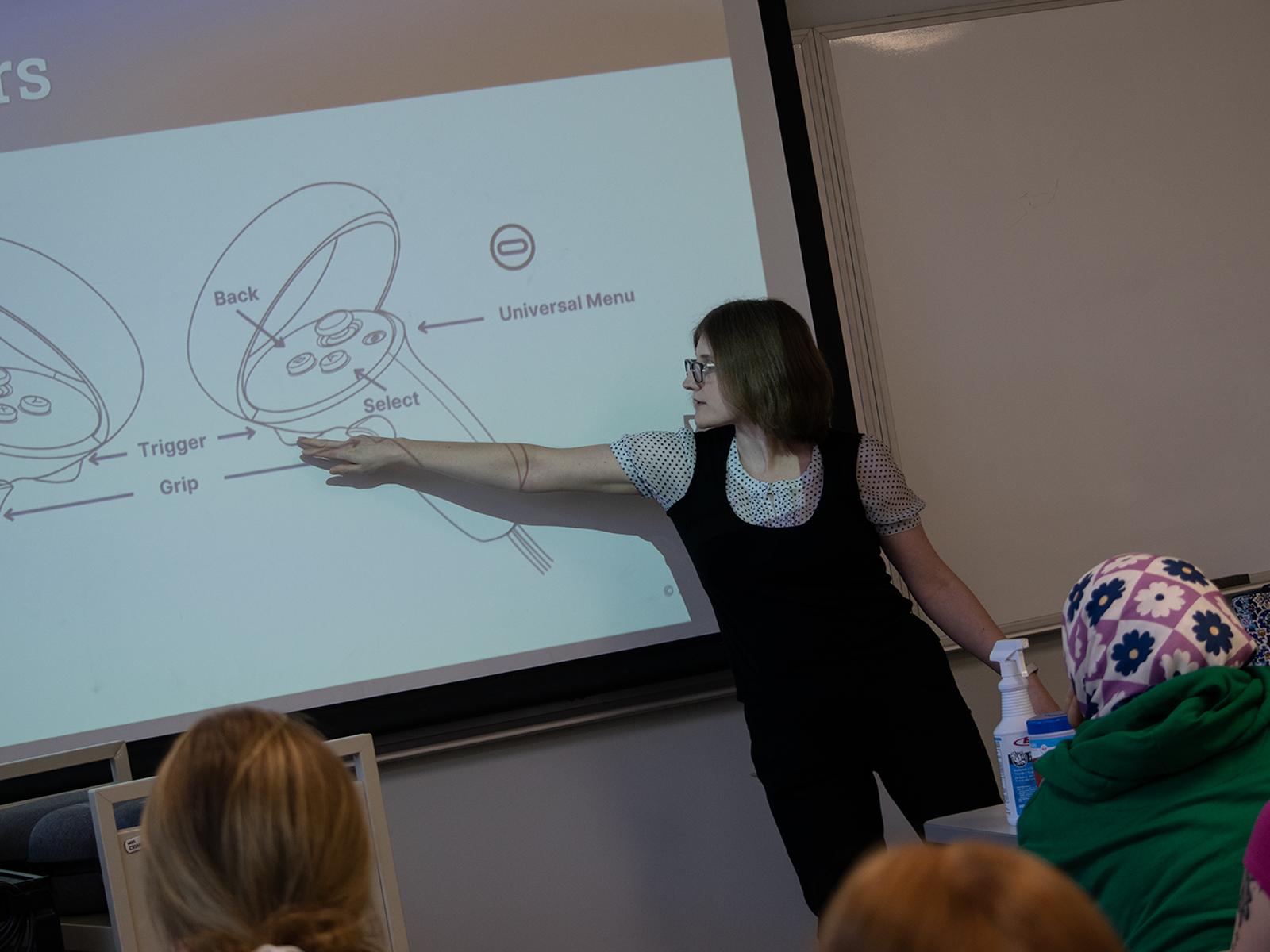 Sarah Kettell, programmer/analyst with the Center for Teaching Excellence at Penn State Harrisburg, points at a screen showing a diagram of virtual reality controllers.