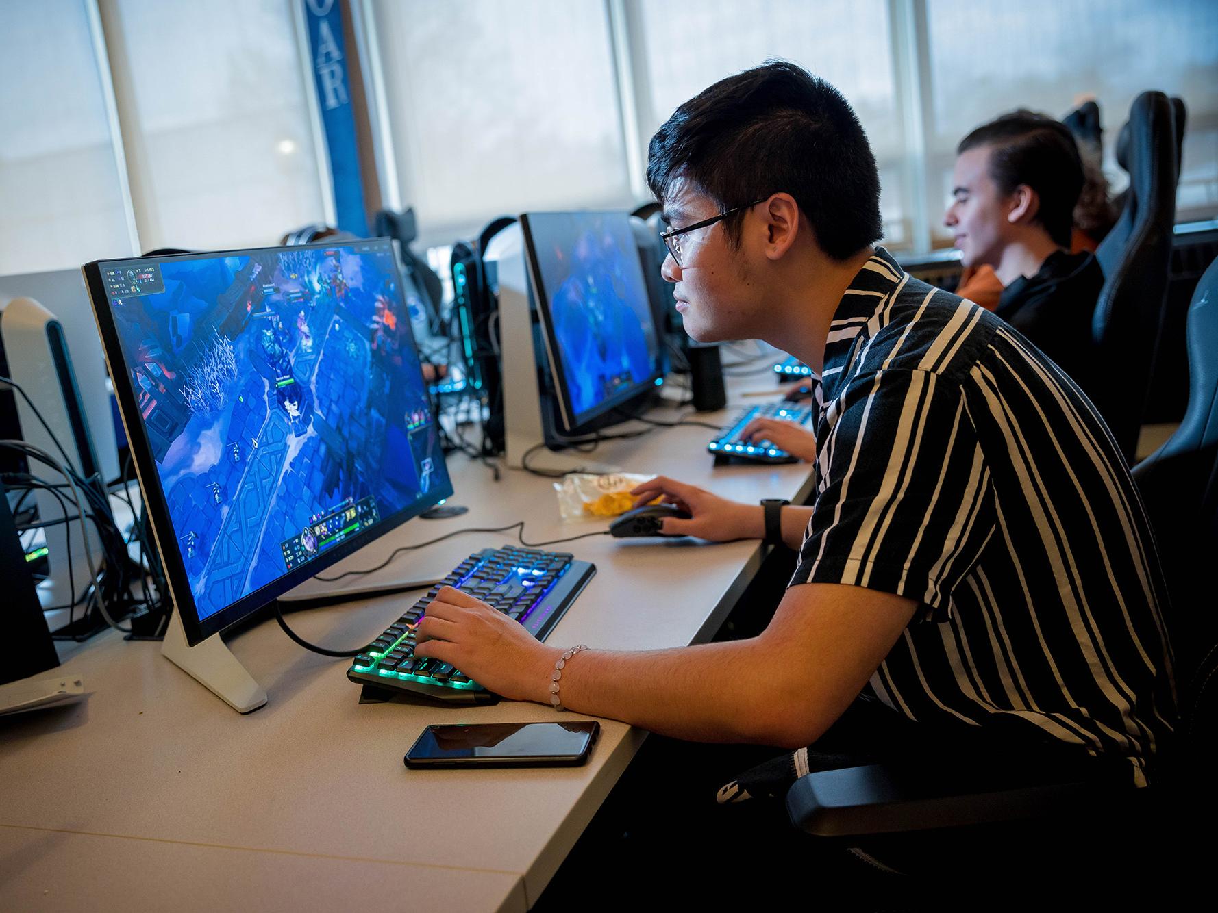 A male student plays a video game in Penn State Behrend's esports lounge.