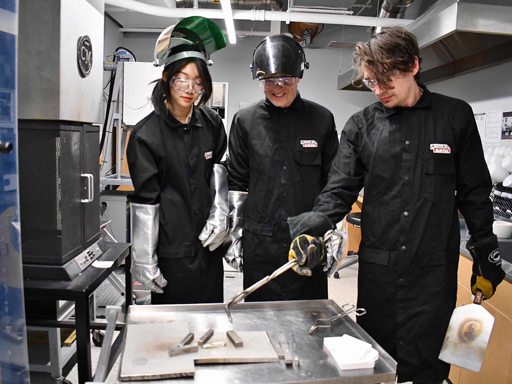 A group of researchers making glass at a furnace