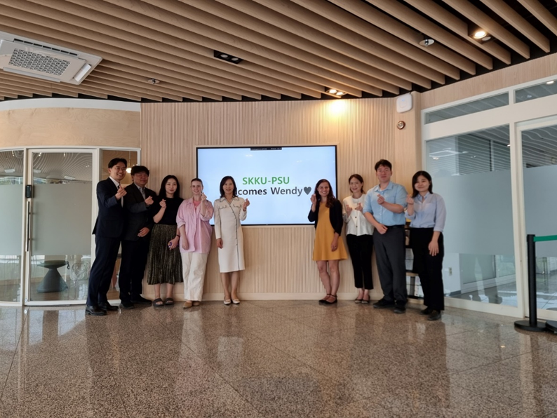 A group of people standing and smiling for the camera in a room