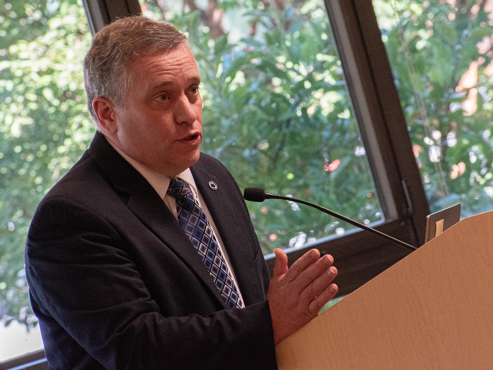 Darrell Bartholomew, associate professor of marketing, speaks at a lectern