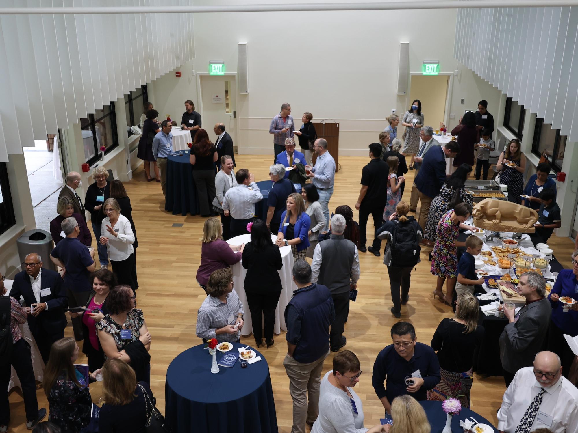Photo from above of guests mingling at faculty celebration event