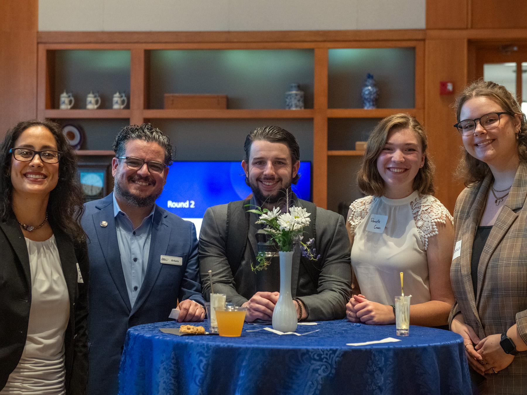 Liberal Arts alumni and students stand around a table during the Career Readiness Summit. From left to right: Evita Salles, class of 2023 (Spanish); Arturo Leon, class of 2006 (psychology and history); Joe Hartzell, fourth-year student majoring in psychology; Danielle Craven, a second-year Liberal Arts pre-major and Monica Michalowski, a fourth-year student majoring in criminology and psychology.