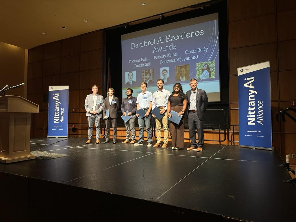 People standing on stage posing for a photo.