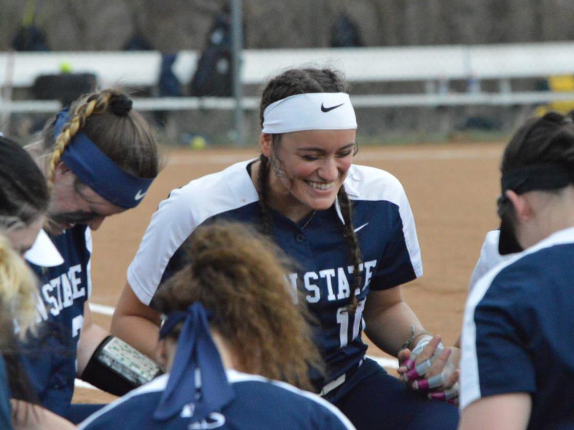Members of Penn State Fayette's softball team huddle for good luck