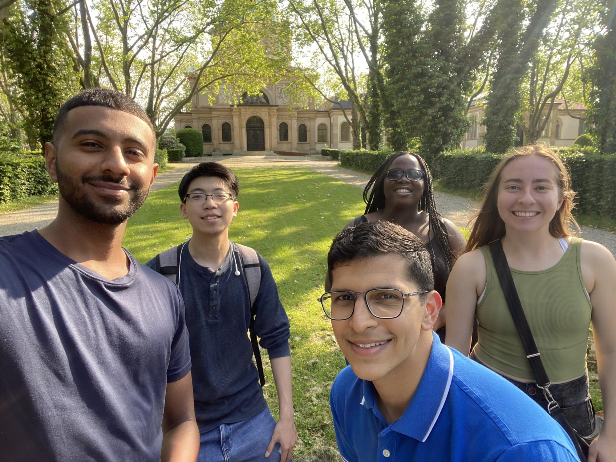 five people standing on a lawn