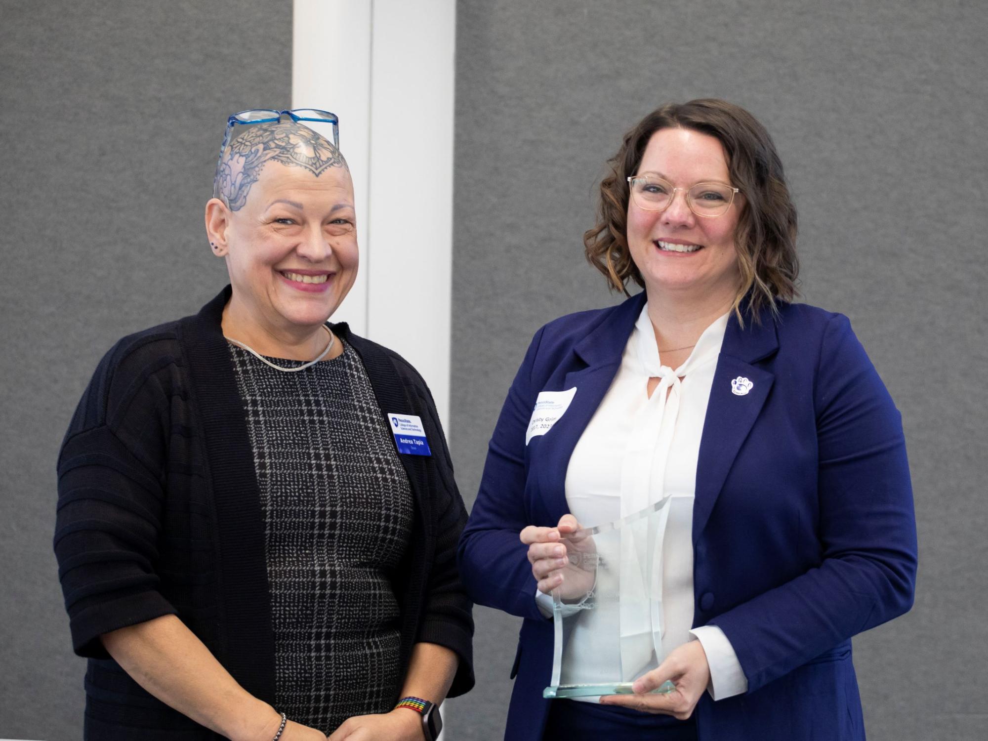 two people in business attire receive award