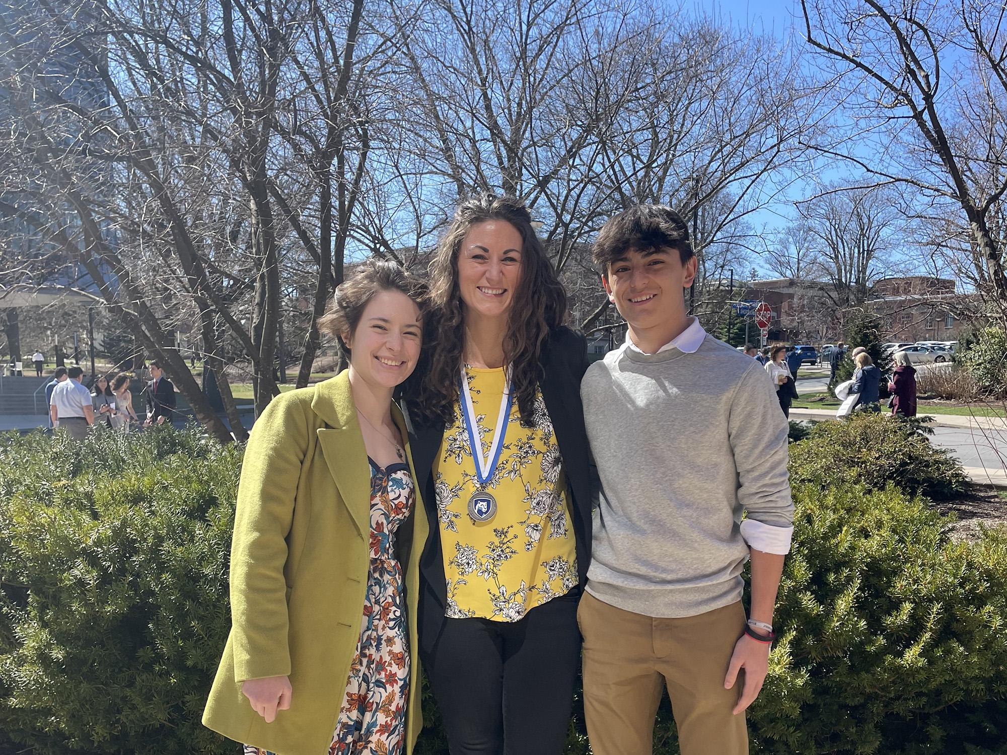 Laura Gamble with her two oldest children, Kota [left] and Wyatt [right], smile while on campus.
