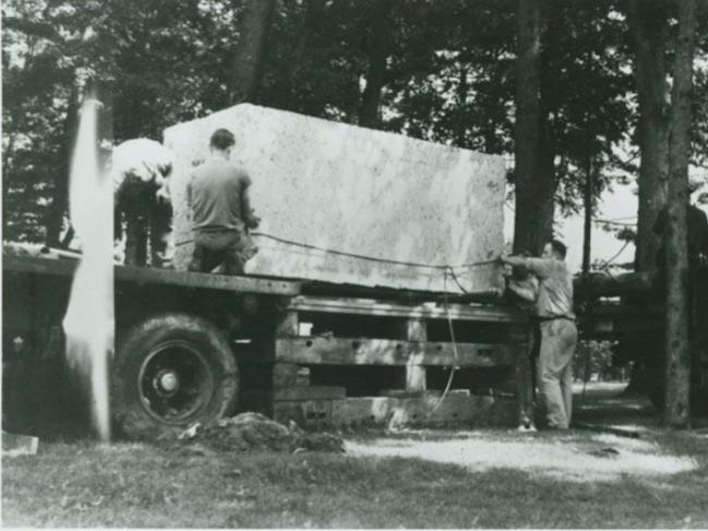 A block of limestone sits on top of a flatbed truck