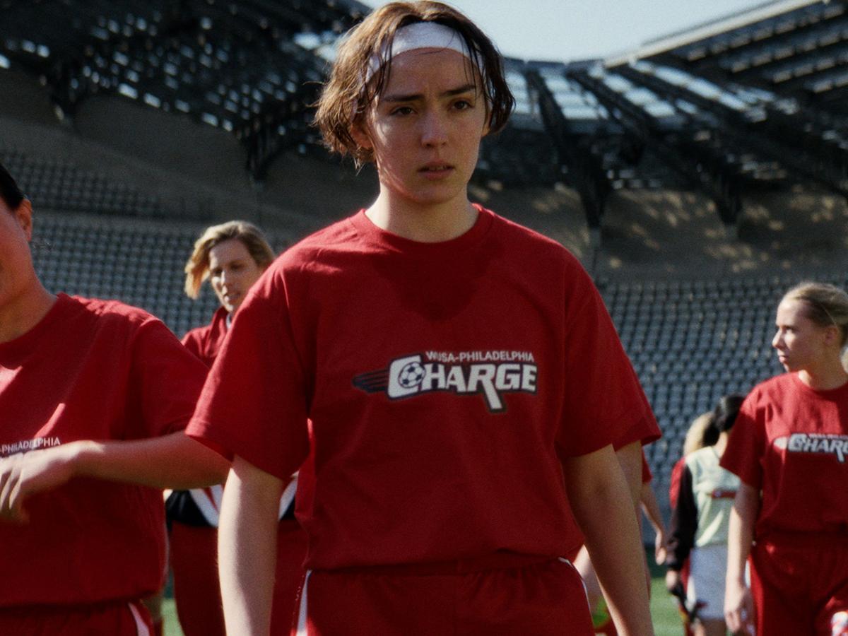 soccer player in red shirt and white headband