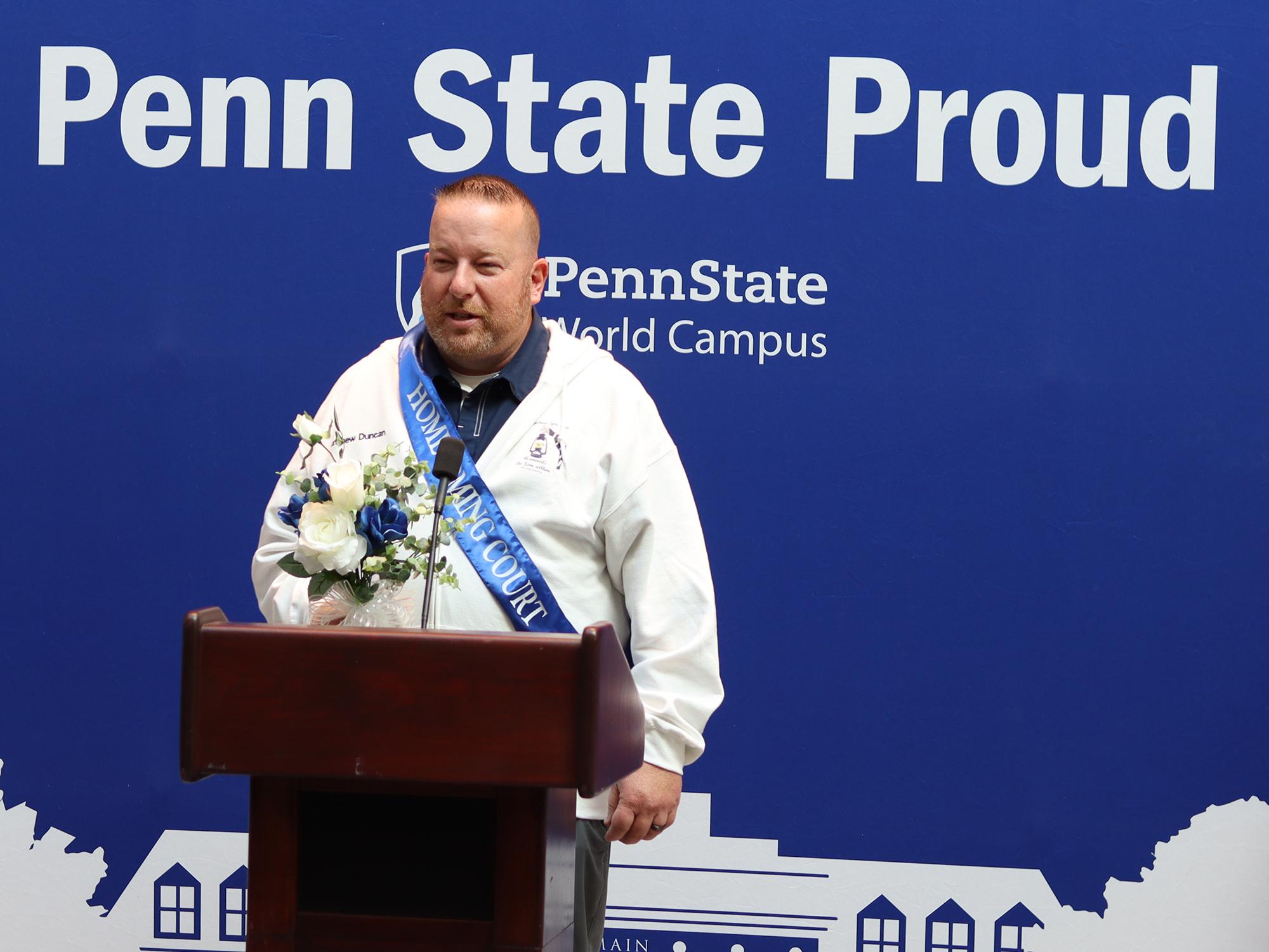 A man speaks at a podium in front of a blue background.