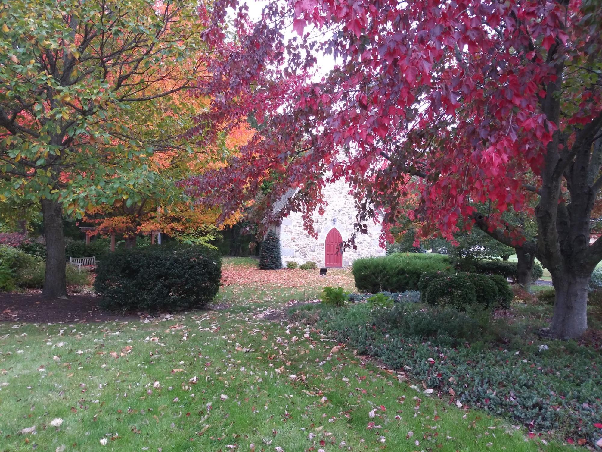Colorful leaves on trees in the foreground of the chapel at Mont Alto.
