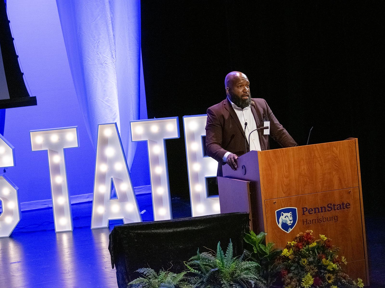Gibran Jones speaks onstage at the Penn State Harrisburg Alumni Awards ceremony