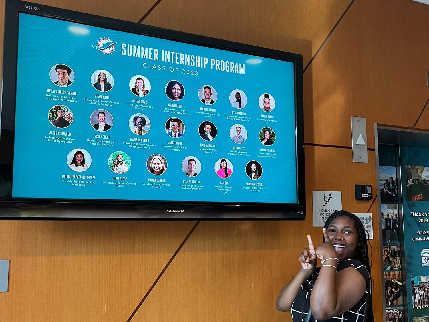 Azziyah LaRue stands inside Hard Rock Stadium and points to a screen that reads “Summer Internship Program Class of 2023,” which features her picture and name as well as those of 19 other interns. 