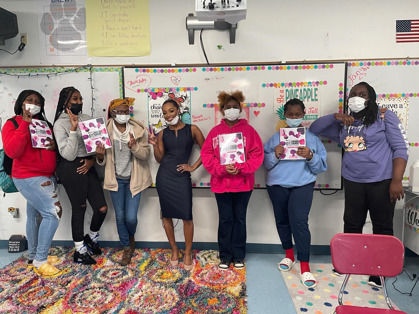 Liberal Arts alumna Khadesia "Keke" Walker (middle) poses with students in front of a whiteboard during a women’s empowerment workshop.