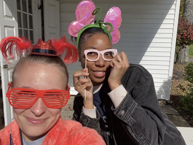 Two students in silly glasses and headbands taking a photo of themselves.