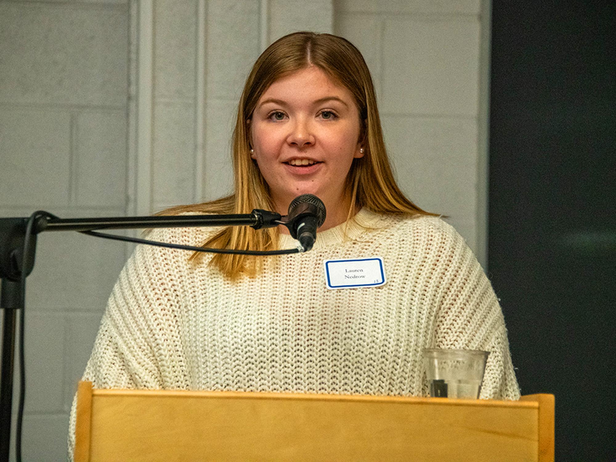 Lauren Nedrow speaking at the podium.