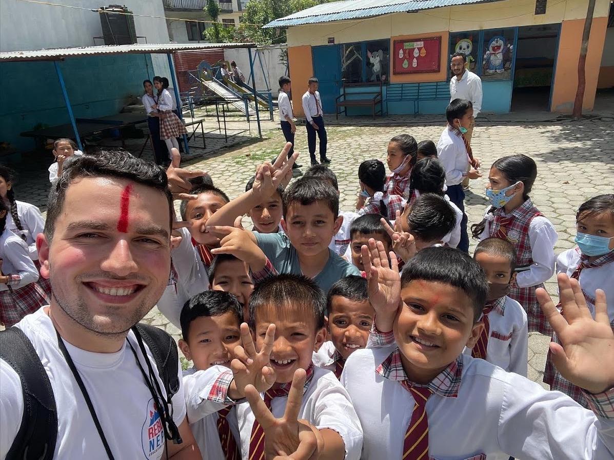 Brandon Bixler posing with children in Nepal