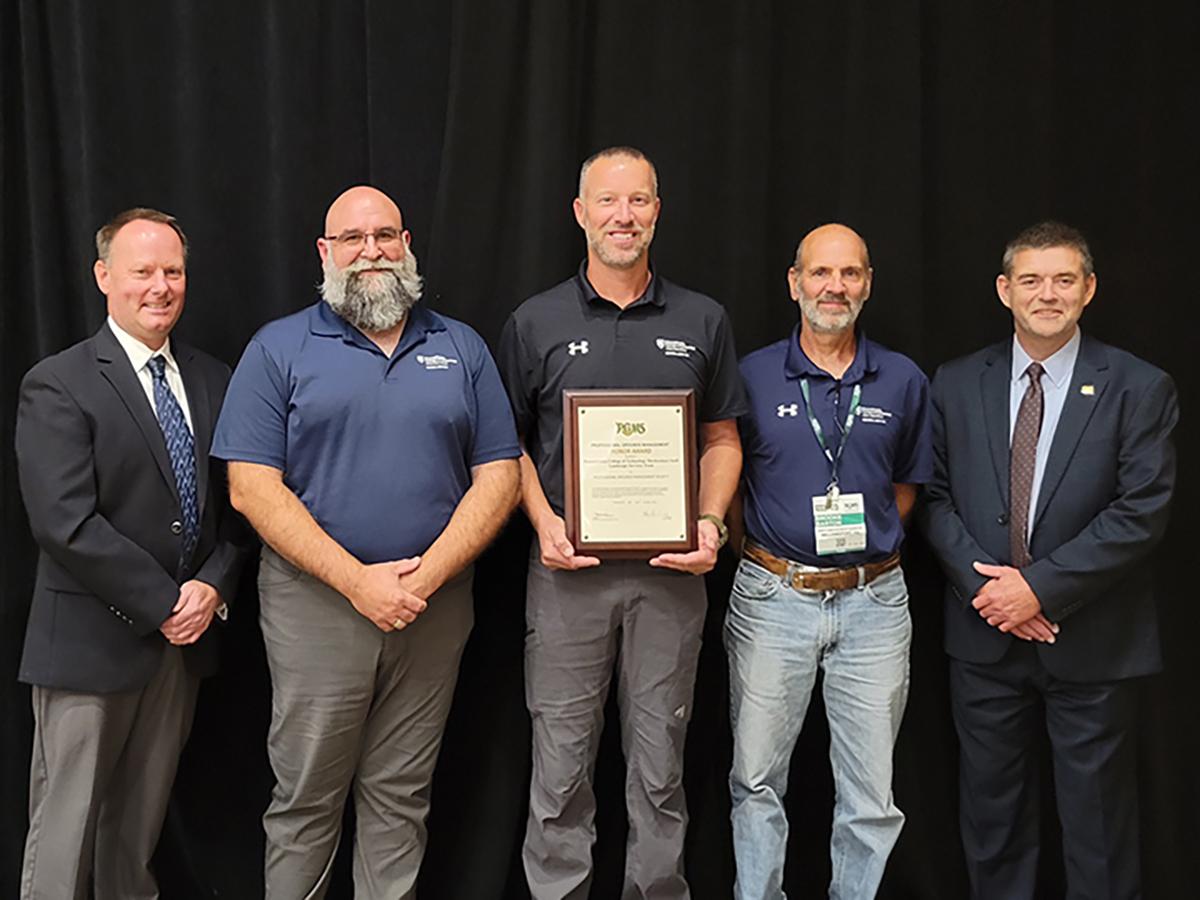 Five people stand in a row for an award presentation