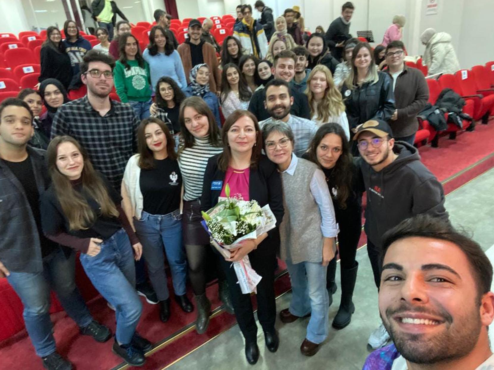 Poyrazli surrounded by a group of students
