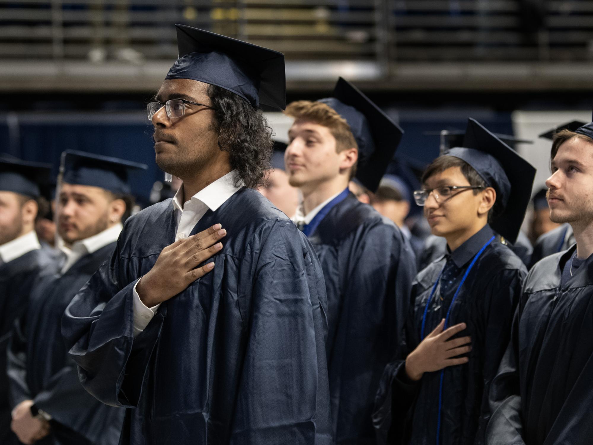 graduates stand for national anthem
