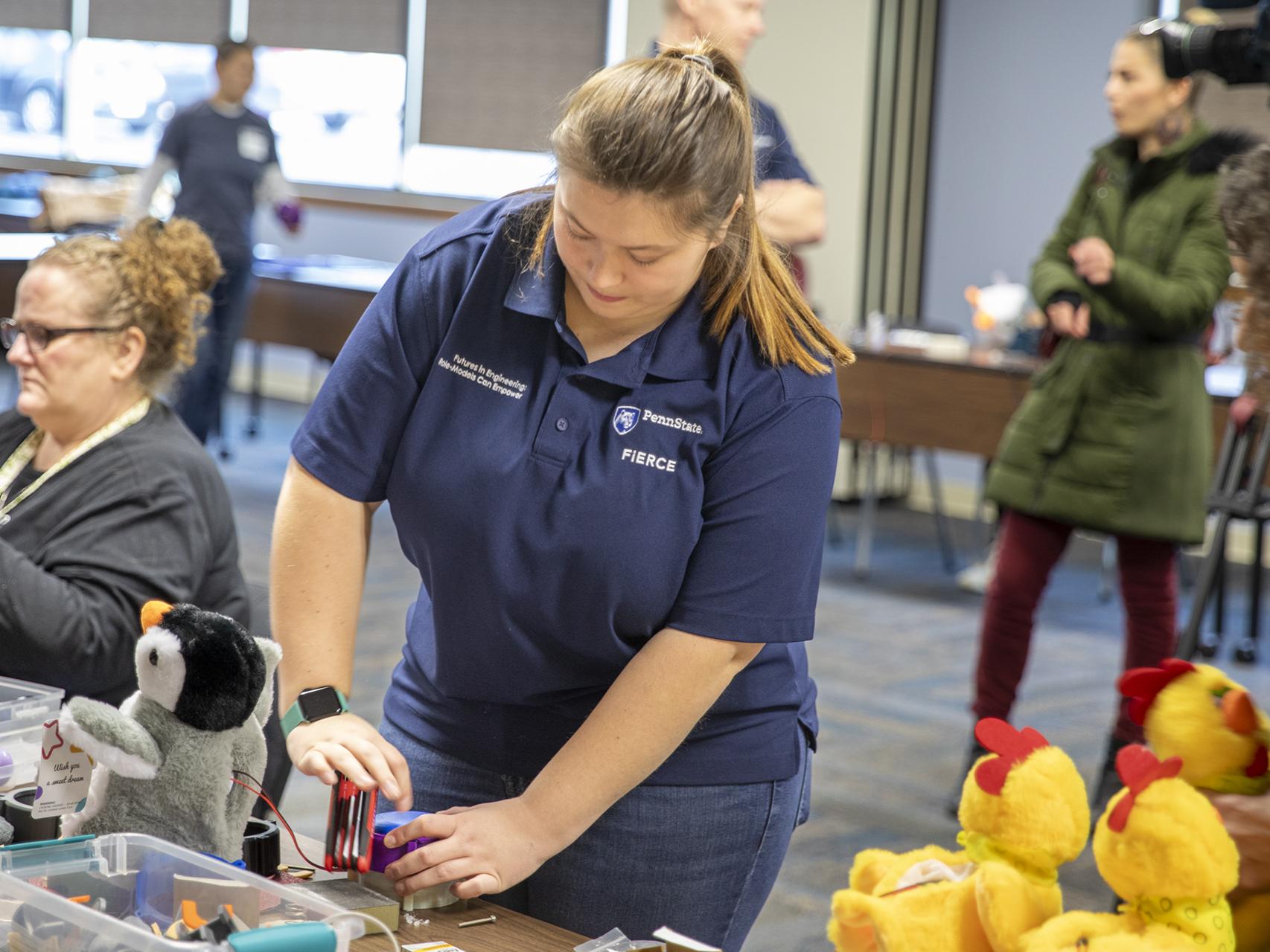 A Penn State Berks student closes the housing around the new accessible button's mechanics.